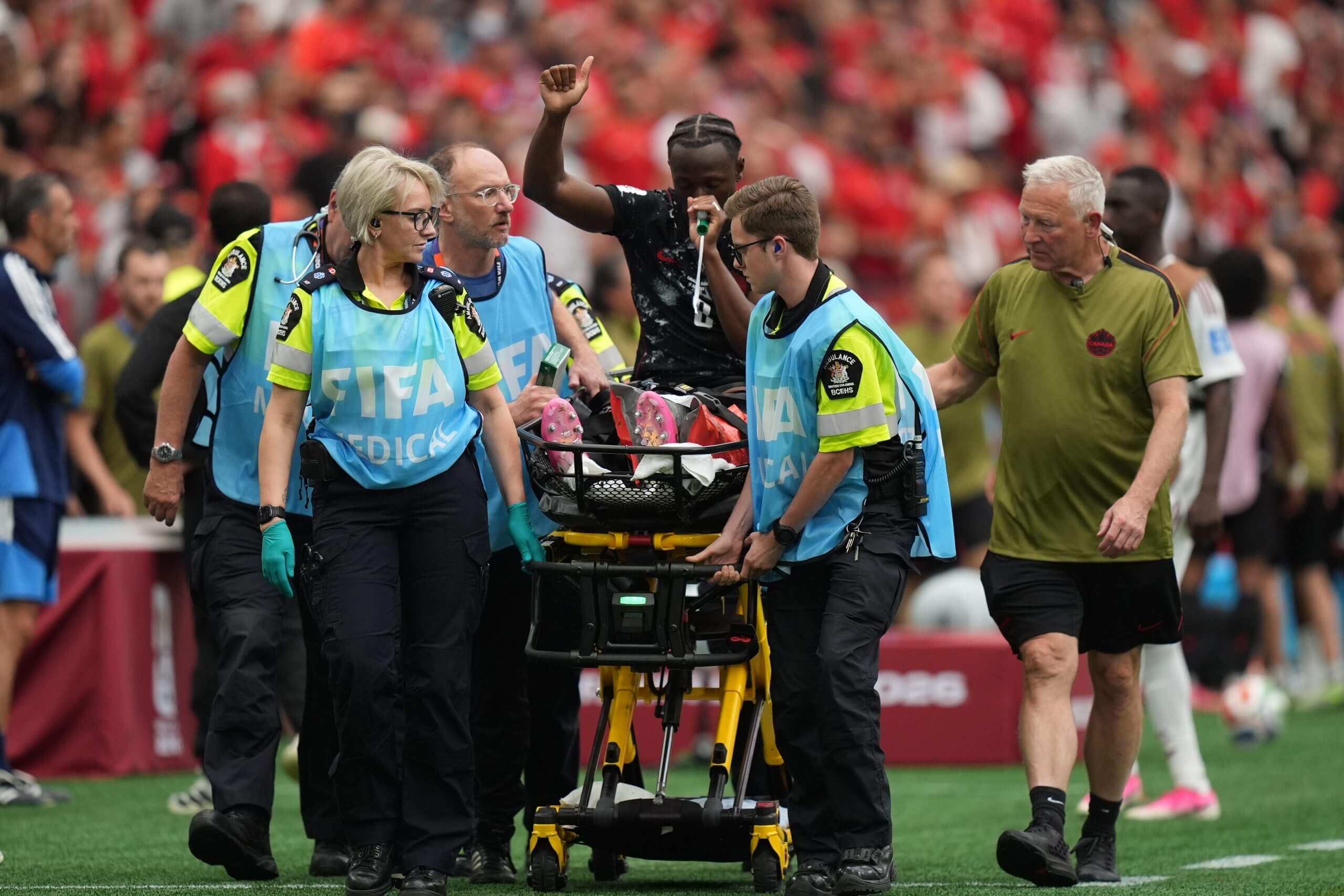 A player is taken off the field on.a sretcher with an oxygen mask over his mouth