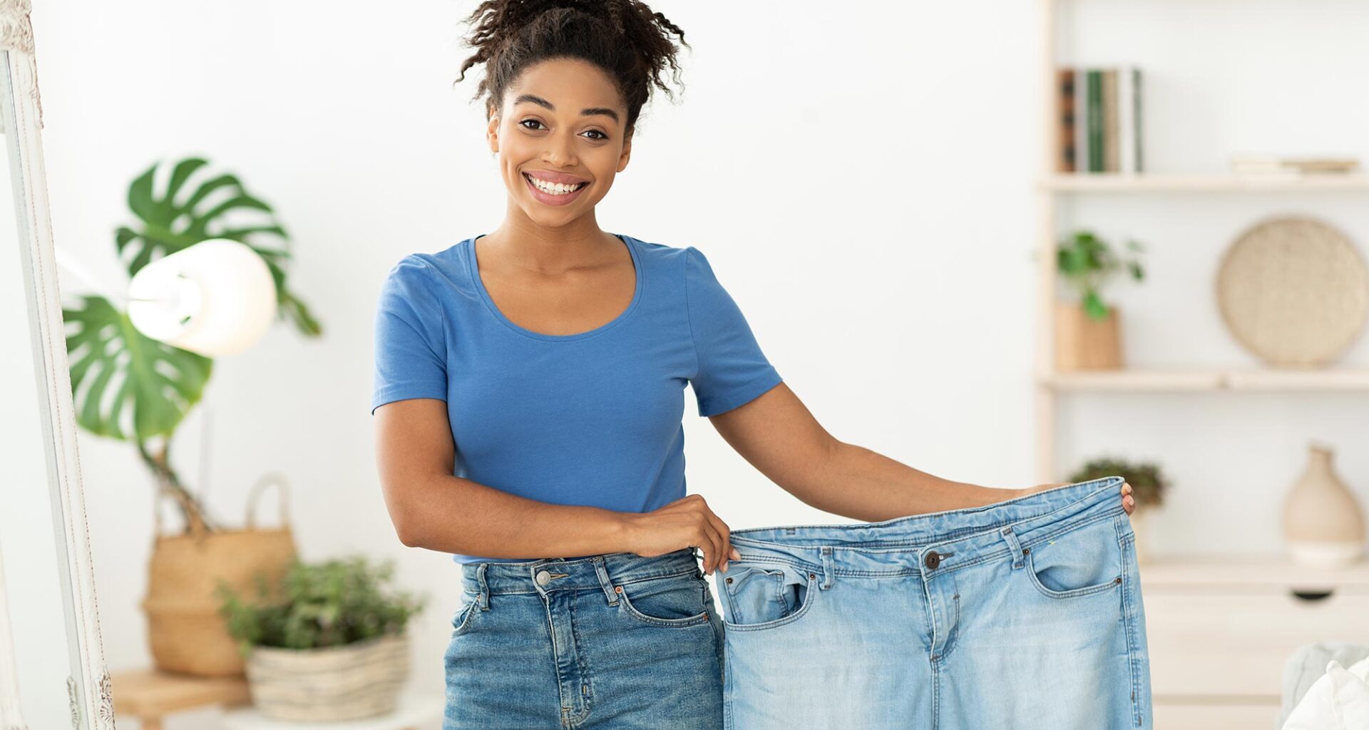 Happy Slim Black Woman Showing Old Oversize Jeans After Successful Weight Loss Diet