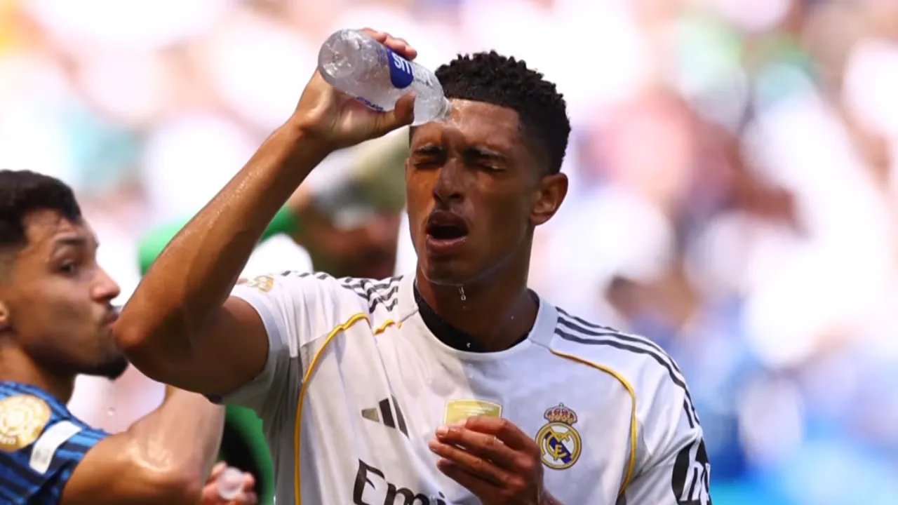 A soccer player pours water on his face during a hot World Cup match