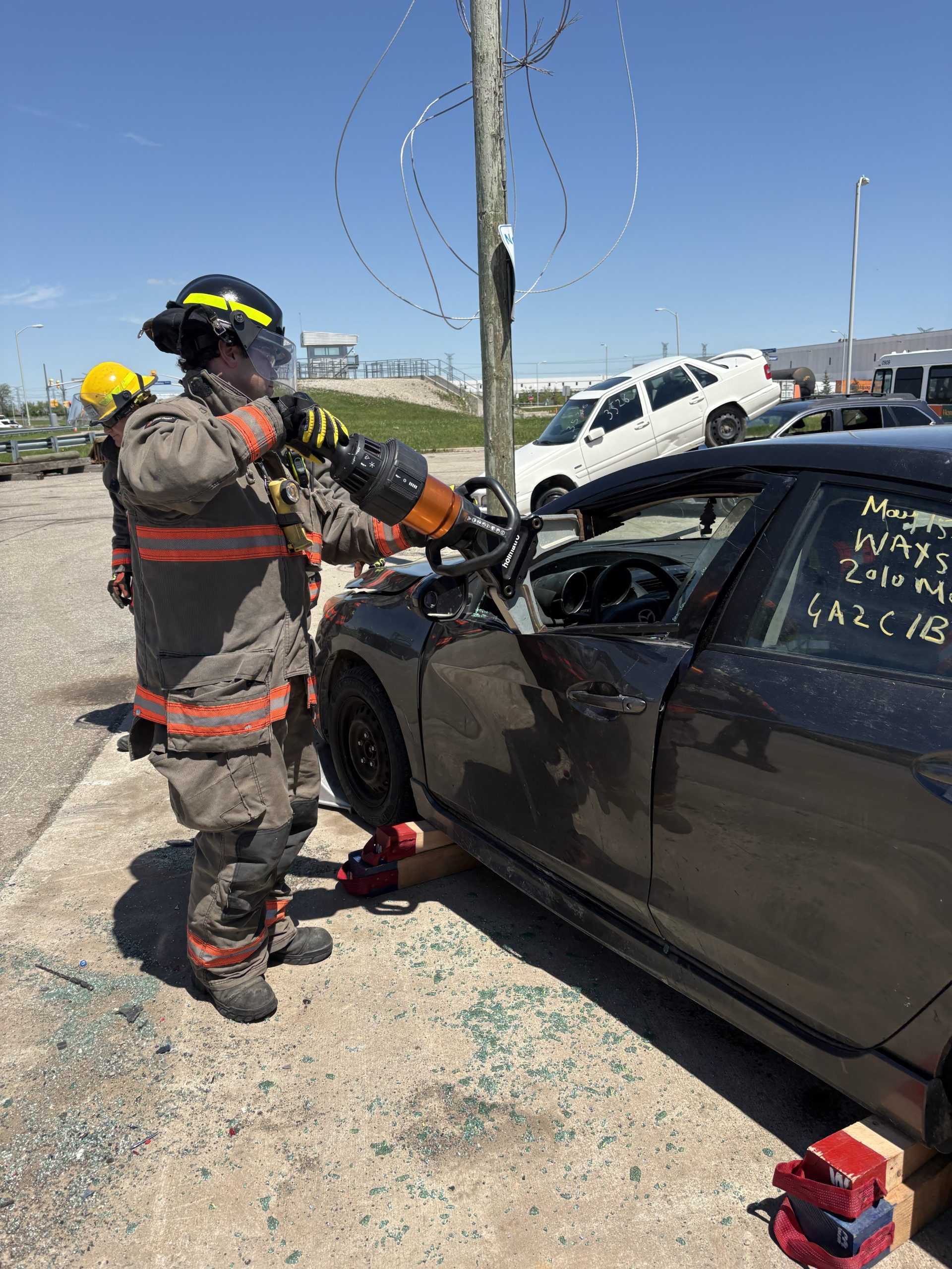 Firefighter using the jaws of life to cut car door