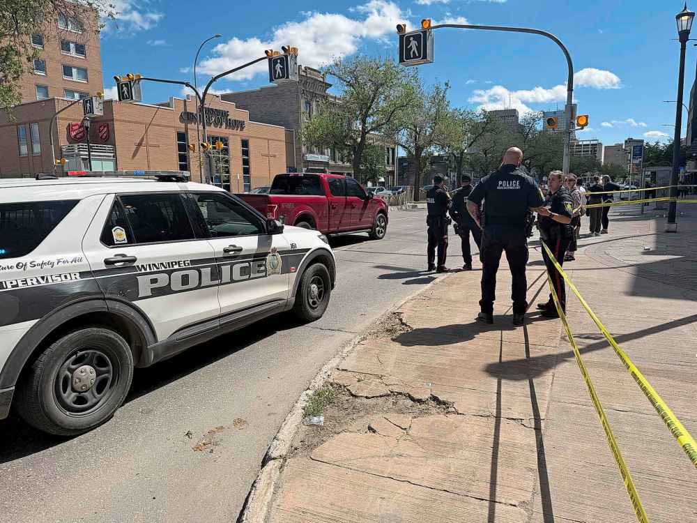 Winnipeg Police Service officers investigate an incident on Henry Avenue Thursday. (Morgan Modjeski / Free Press files)