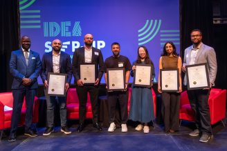A group of people hold certificates while standing on a stage.