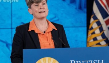 Health Minister Josie Osborne, a light-skinned woman with short hair, stands at a podium.