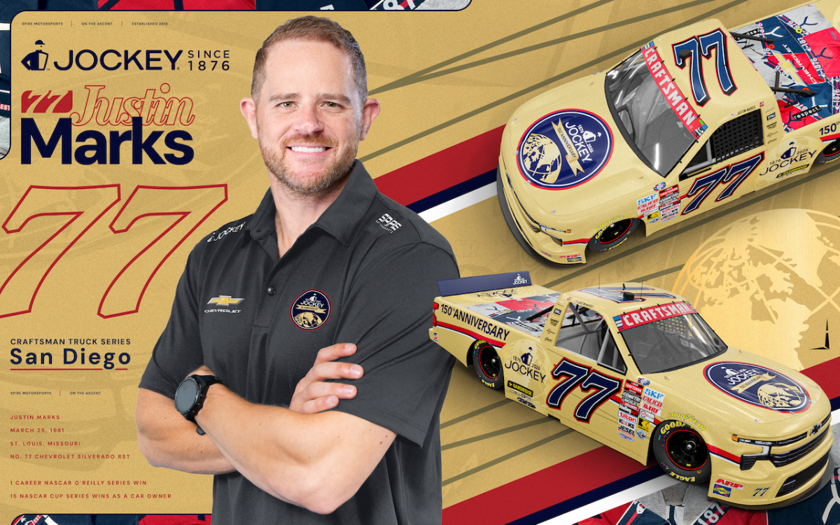 Portrait of NASCAR driver Justin Marks with two yellow race cars and Jockey branding on a gold backdrop.