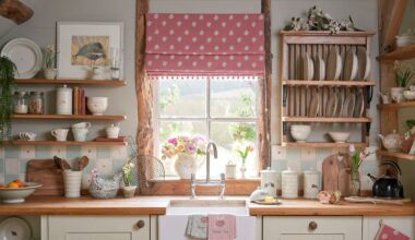 Kitchen sink beneath a window with a pink Roman blind, featuring wooden countertops, a farmhouse sink, and a wooden plate rack