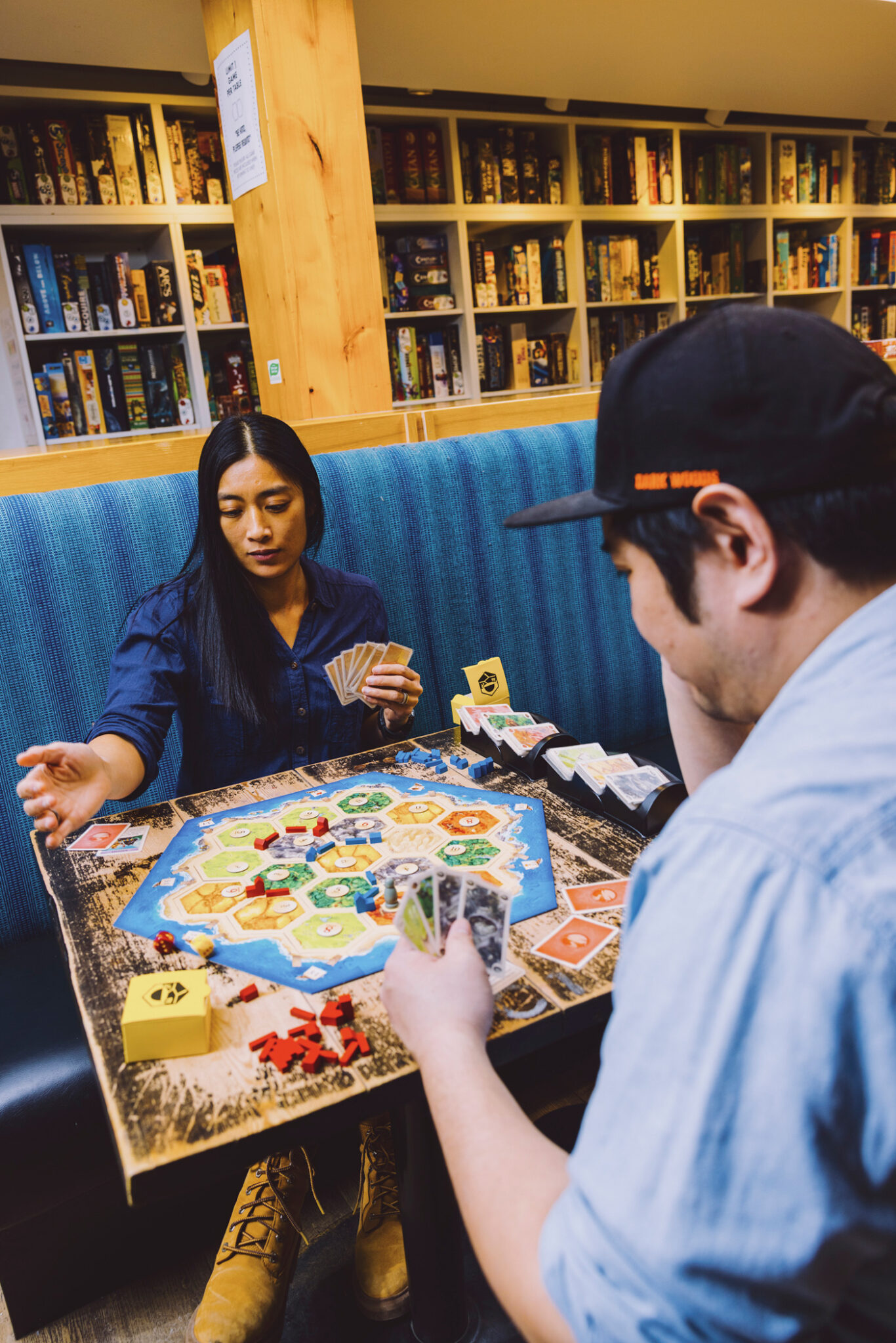 Two people play a board game in a board game cafe