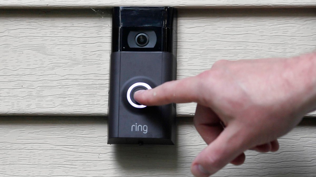 FILE - In this July 16, 2019, file photo, Ernie Field pushes the doorbell on his Ring doorbell camera at his home in Wolcott, Conn. Amazon says it has considered adding facial recognition technology to its Ring doorbell cameras. The company said in a letter released Tuesday, Nov. 19 by U.S. Sen. Ed Markey that facial recognition is a ???contemplated, but unreleased feature??? of its home security cameras. The Massachusetts Democrat wrote to Amazon CEO Jeff Bezos in September raising privacy and civil liberty concerns about Ring???s video-sharing partnerships with hundreds of police departments around the country. (AP Photo/Jessica Hill, File)