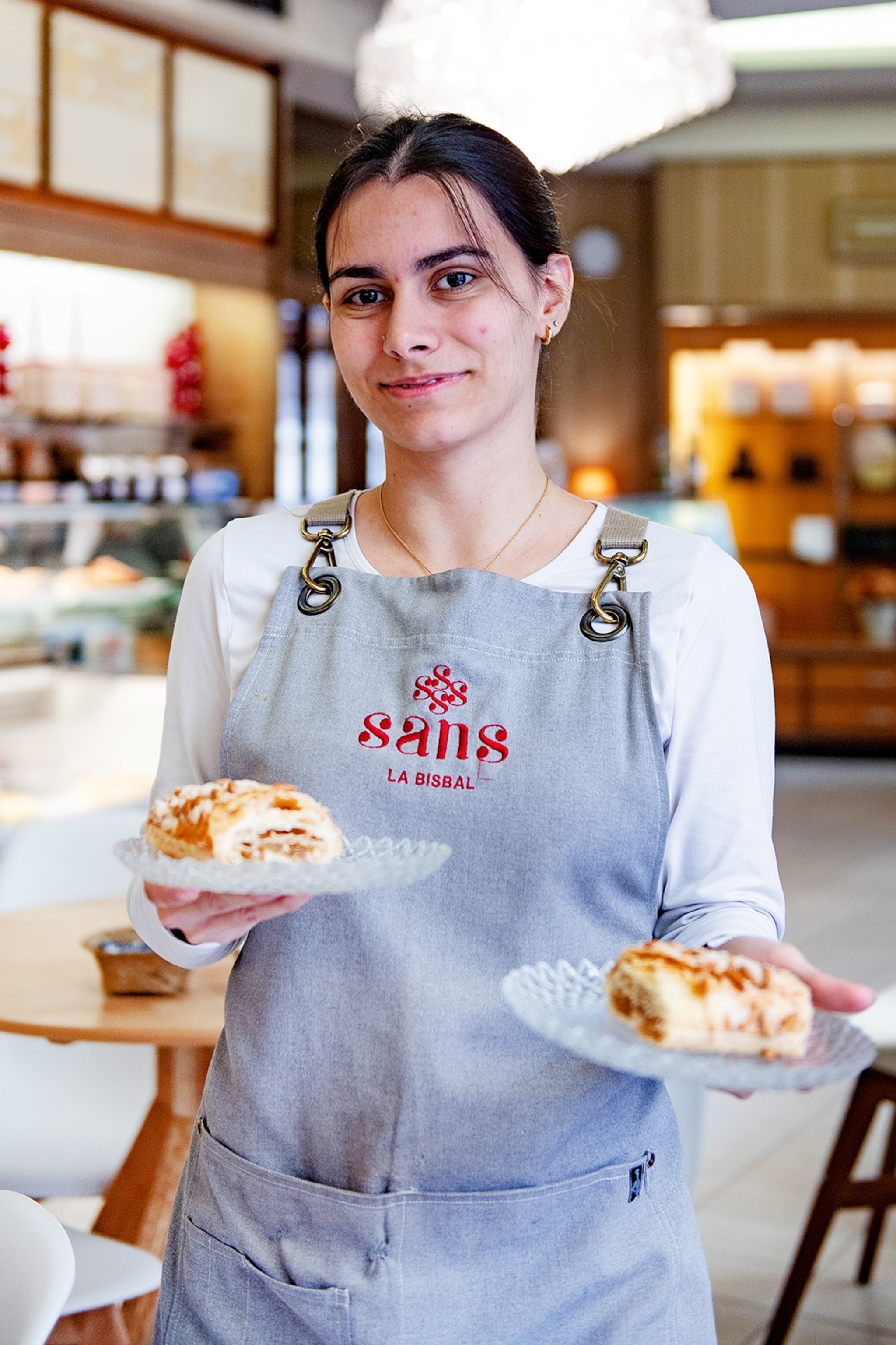 A café worker holds local pastries.