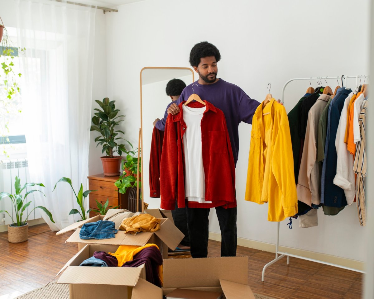 Man organizing and decluttering clothes at home