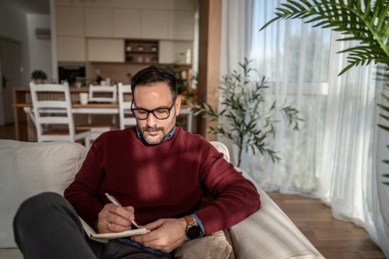 A man writes in a notebook