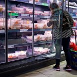 A customer looks at packages of chilled chicken cuts in a part-empty refrigerated display unit at a Lidl supermarket store in Walthamstow, west London, on September 21, 2021. (Photo by Tolga Akmen / AFP) (Photo by TOLGA AKMEN/AFP via Getty Images)