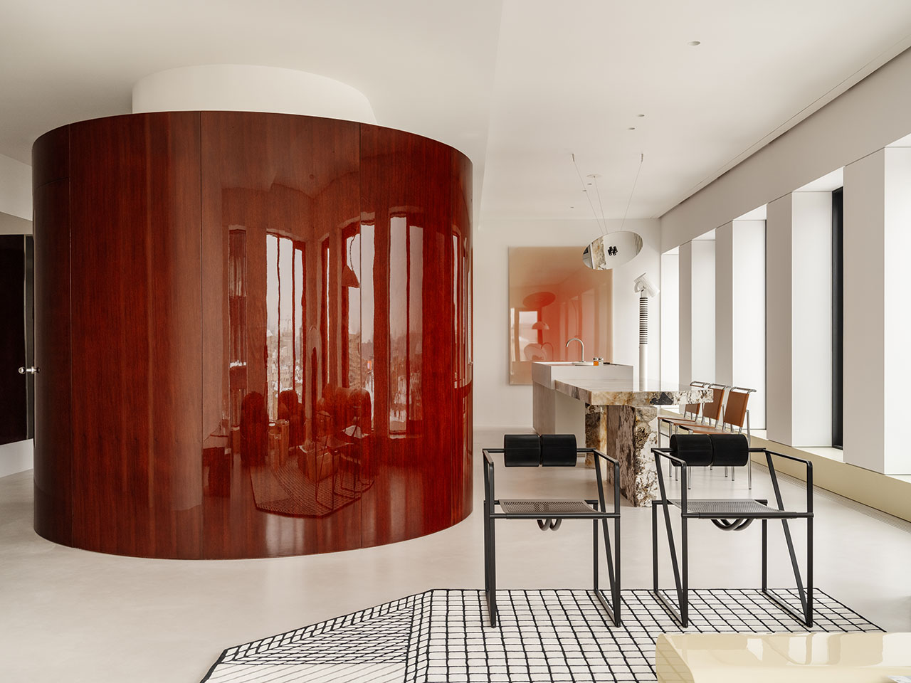 Modern Antwe interior with a glossy curved wood wall, minimalist furniture, large windows, and neutral colors, featuring a marble kitchen island and geometric decor elements.