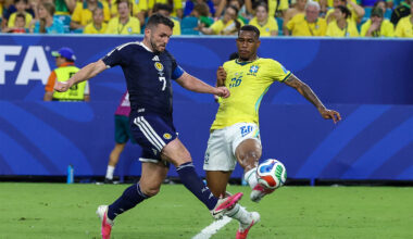 ohn McGinn #7 of Scotland and Rayan #26 of Brazil battle for the ball during a FIFA World Cup match.