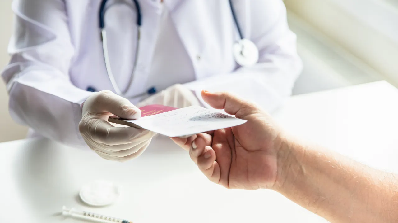 A doctor checks a traveler’s vaccine record before World Cup travel