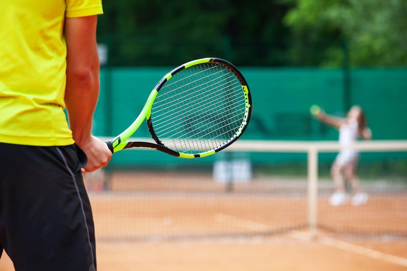 Male tennis player holding tennis racket in a ready position