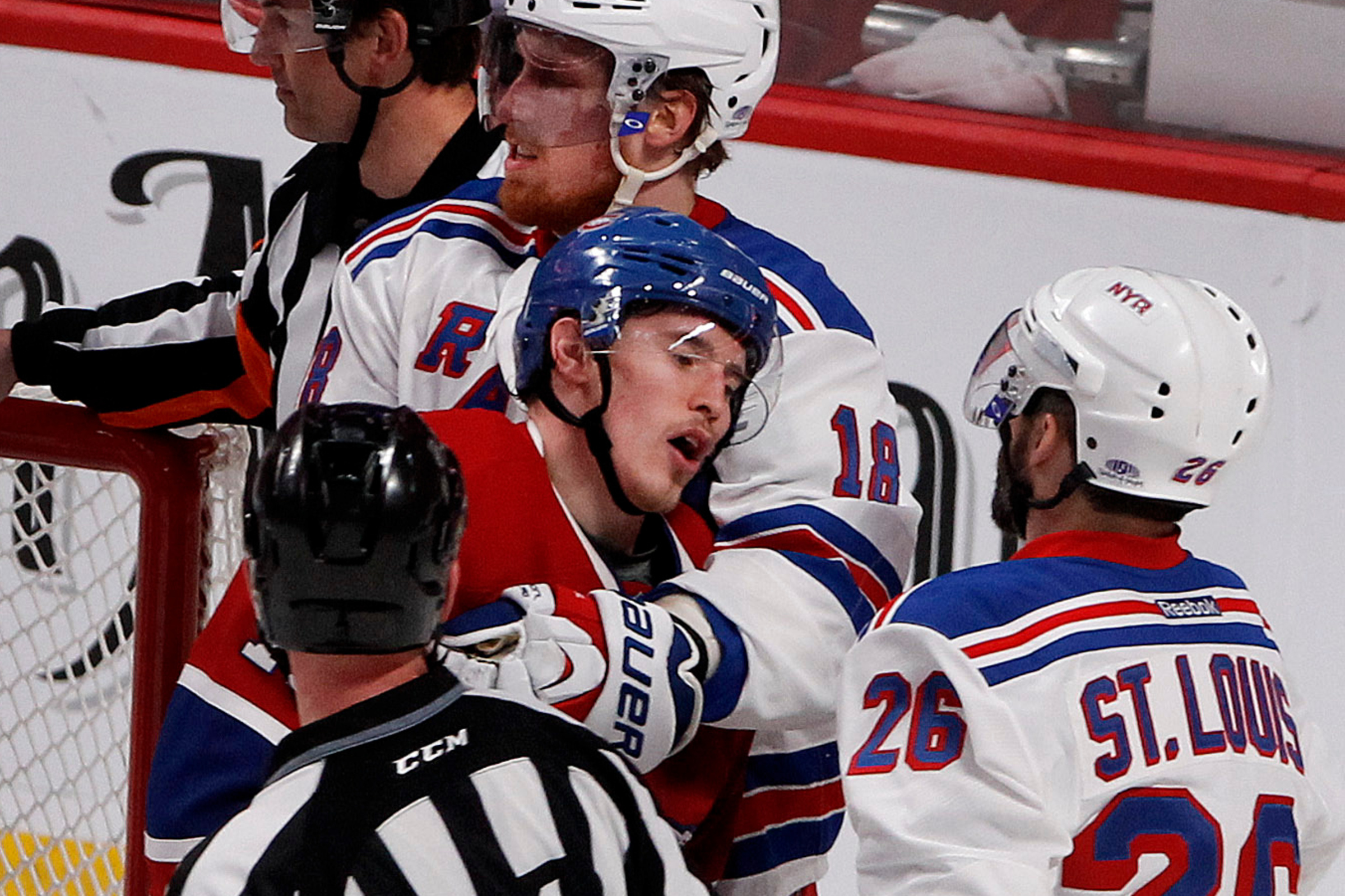 Brendan Gallagher is being held back by a Rangers player near the net.