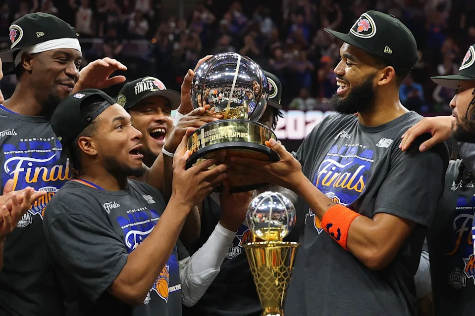 CLEVELAND, OHIO – MAY 25: Karl-Anthony Towns #32 and Miles McBride #2 of the New York Knicks celebrate with the Bob Cousy Trophy after defeating the Cleveland Cavaliers 130-93 in Game Four of the NBA Eastern Conference Finals at Rocket Arena on May 25, 2026 in Cleveland, Ohio. (Photo by Gregory Shamus/Getty Images)