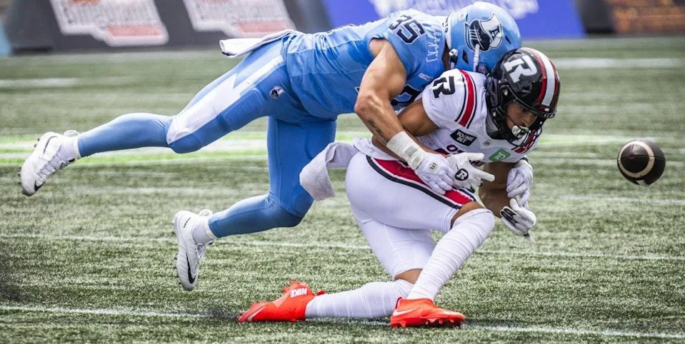Toronto’s Isaac Darkangelo knocks the ball away from the Redblacks’ Keelan White during the first half.