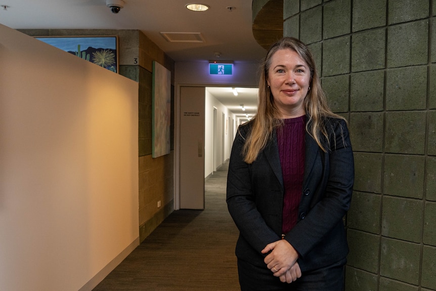 Woman standing at the end of a corridor.