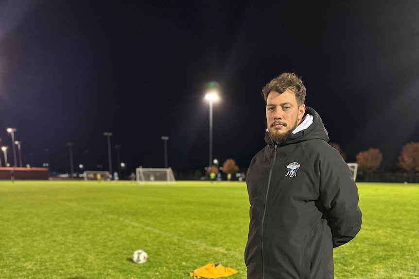 Soccer coach wearing black jacket in the ground