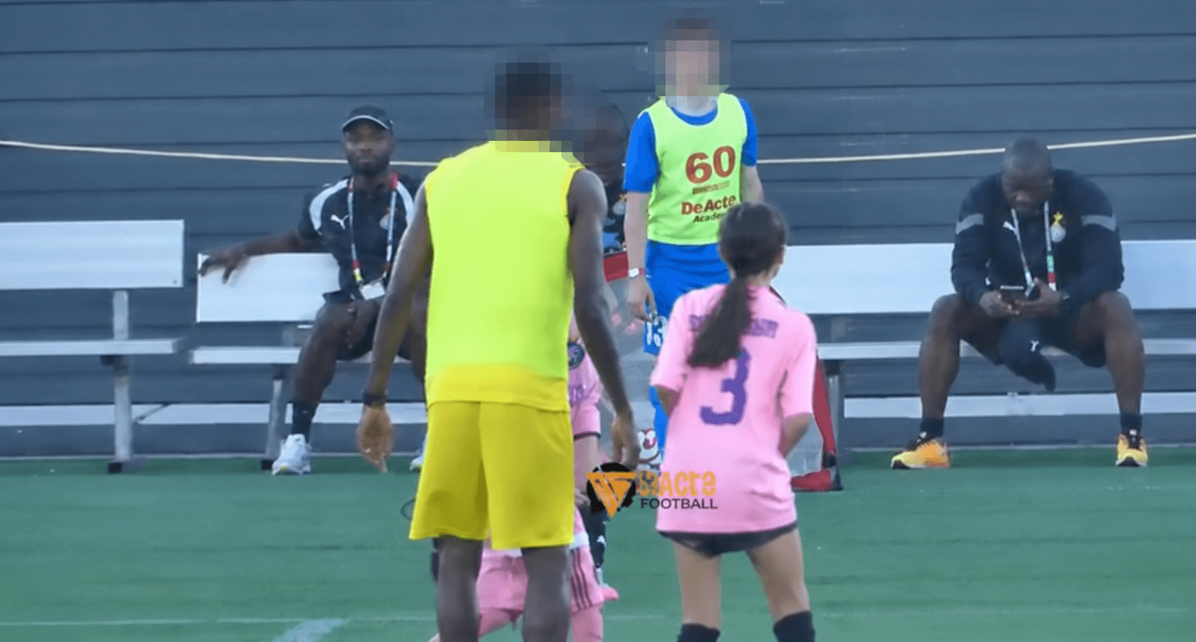 The backs of players at a soccer game