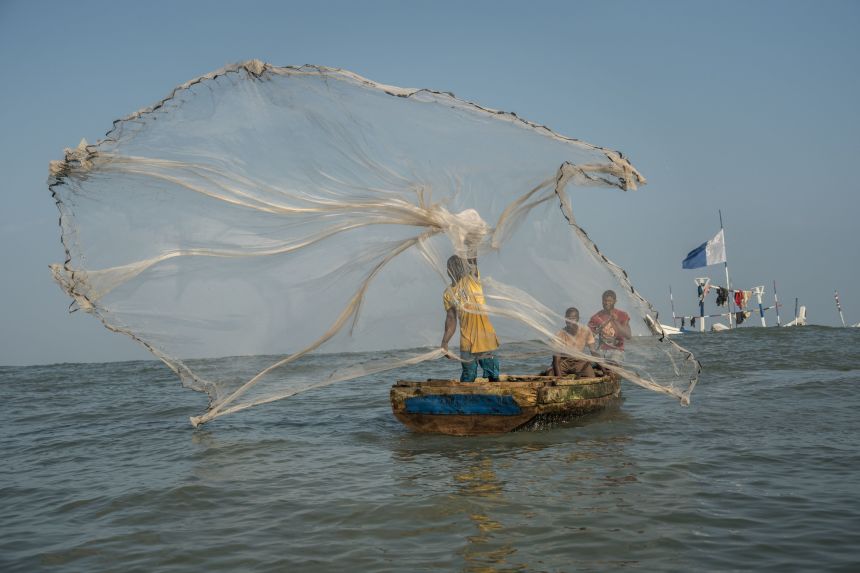 A fisherman throws a cast net in Ghanaian waters — a traditional method that has long sustained coastal communities