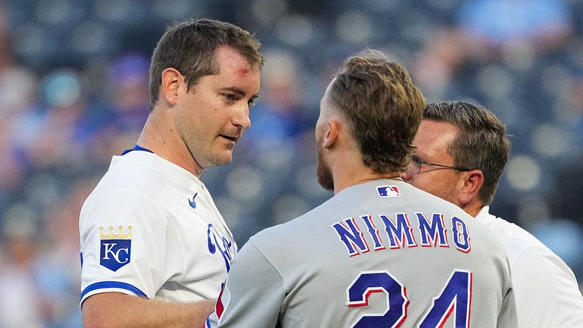 Texas Rangers right fielder Brandon Nimmo talks with Kansas City Royals starting pitcher Seth Lugo at Kauffman Stadium.