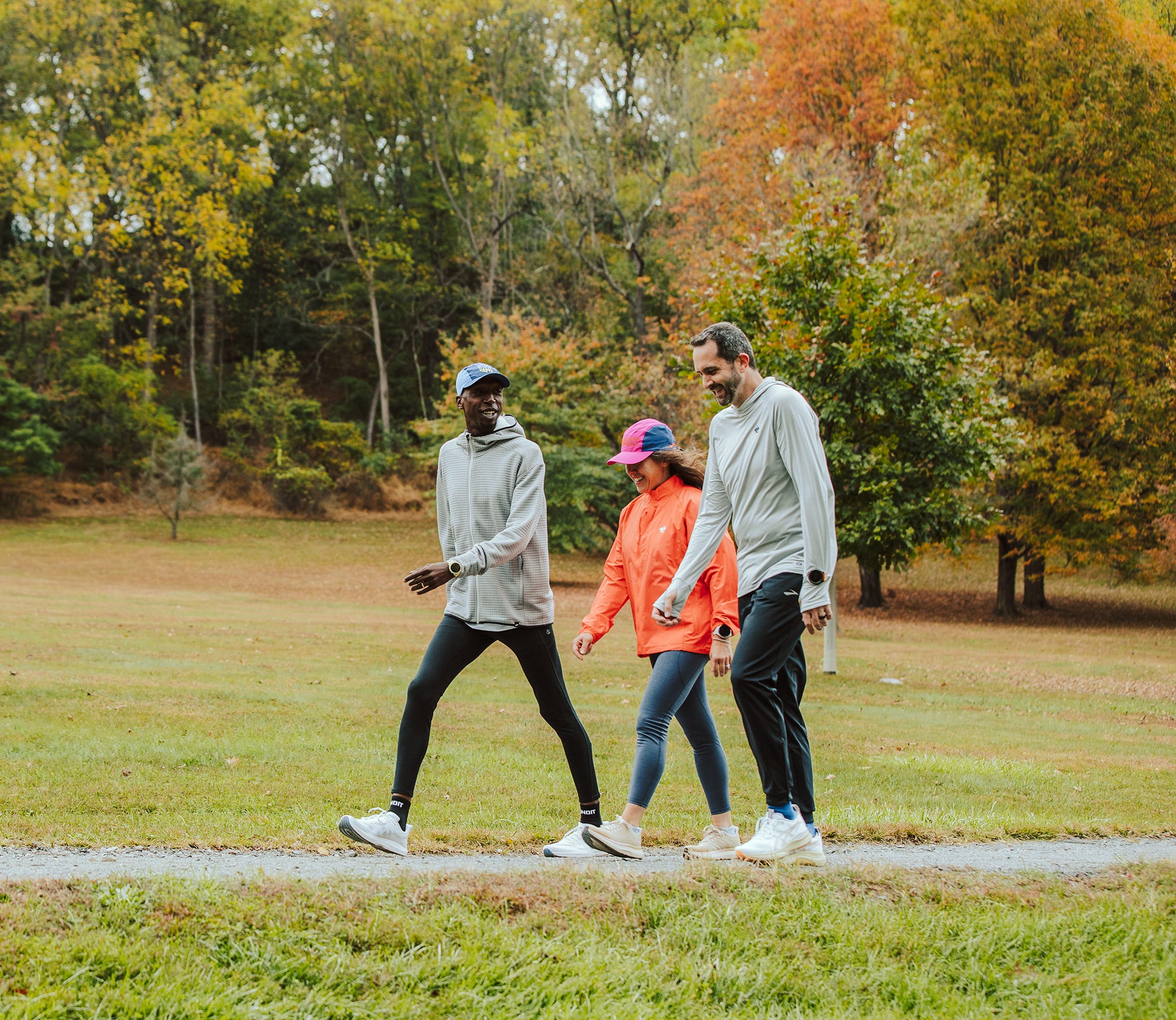 Group walking on a pathway in a park during autumn.