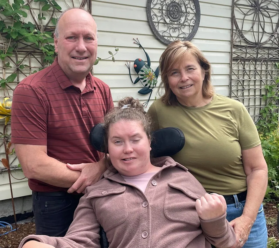 Aisha Strange, pictured in between her mother, Cathy, and father, Kevin, received a letter earlier this month indicating she would be automatically moved from AISH to the new program in July.