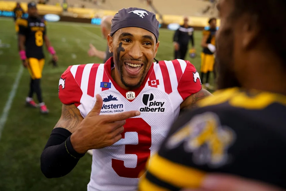 Calgary Stampeders' Vernon Adams Jr. laughs with Hamilton Tiger-Cats wide receiver Kenny Lawler after the Stampeders defeated the Tiger-Cats in CFL football game action in Hamilton on Oct. 11, 2025.