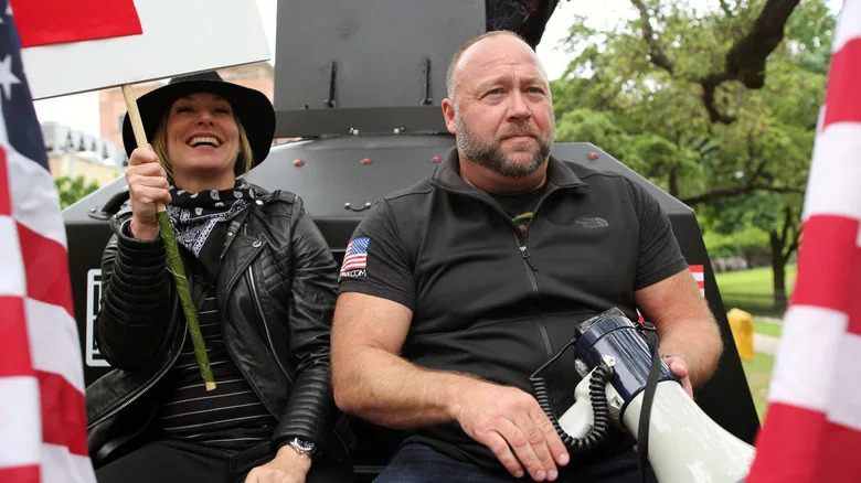 Austin, Tx/USA - Apr. 18, 2020: Alex Jones, with his wife Erika Wulff Jones, sits in the bed of an armored truck before leaving a rally protesting Covid-19 stay at home orders promoted by Infowars.