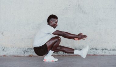 Male athlete doing exercise by white wall
