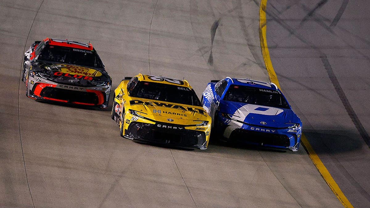 Denny Hamlin, Christopher Bell, and Chase Briscoe racing NASCAR cars on a track