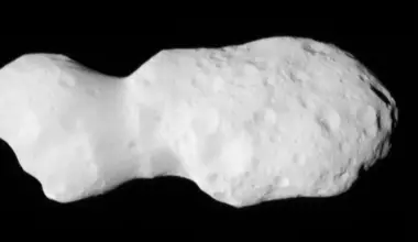 Asteroid wobbles in space: Closeup image of a potato-shaped rock with a narrow waist, covered with craters.