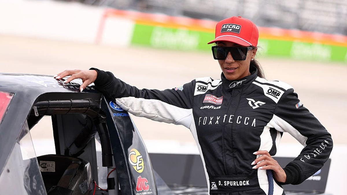 Dystany Spurlock standing on the grid near the #69 Foxxtecca Ford at Dover Motor Speedway