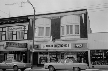 1974: 6169 Fraser St. in Vancouver. Visible are the business signs for Autoplan, Brendon Bros. Ltd. Real Estate and Insurance and Union Electronics.