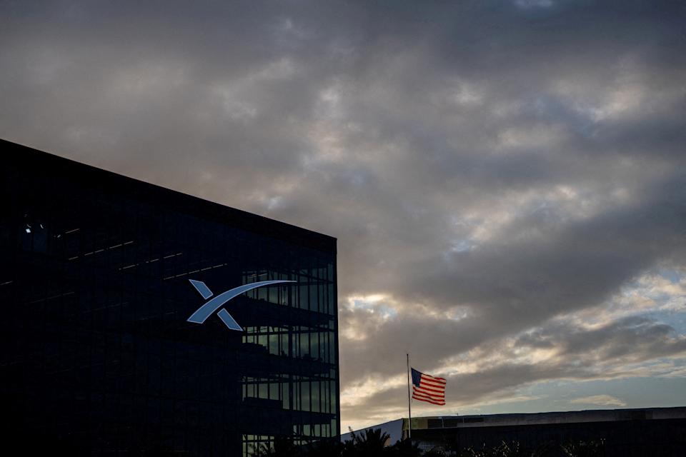 FILE PHOTO: A U.S. flag flies near SpaceX office building as the company prepares to file for an initial public offering (IPO), in Starbase, Texas, U.S. April 21, 2026. REUTERS/Carlos Barria/File Photo
