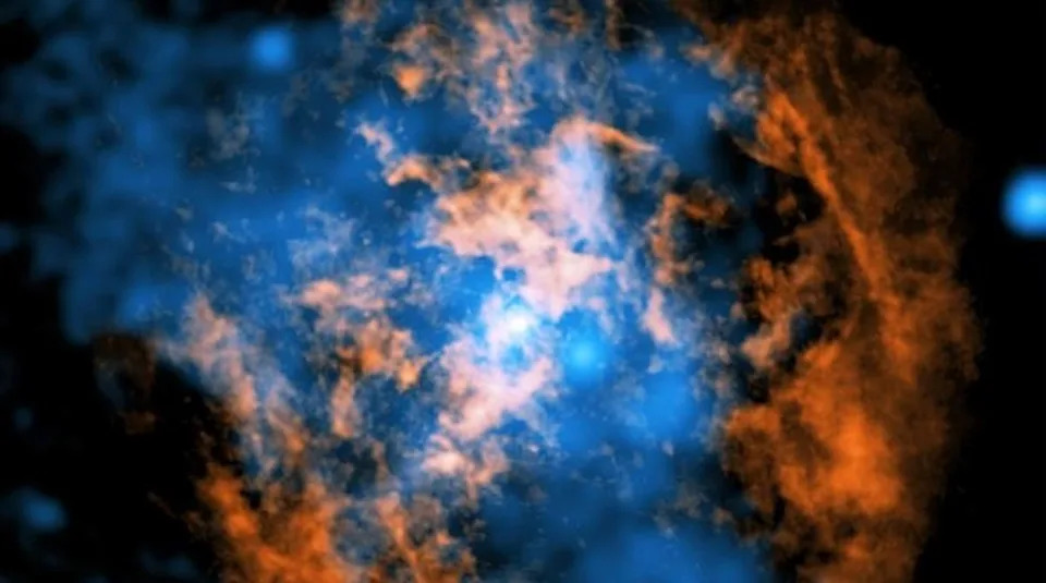 Astronomers say they’ve solved a longstanding mystery about Sagittarius A*, the supermassive black hole in the center of our galaxy. The white dot in the center of this composite image shows the black hole, the orange and blue areas mark surrounding gas and X-ray data and a cone-shaped cavity seen in the orange data is the key to their findings (X-ray: NASA/CXC/Northwestern Univ./M. Gorski; Radio: ESO/NAOJ/NRAO/ALMA; Image processing: NASA/CXC/SAO/K. Arcand and P. Edmonds)