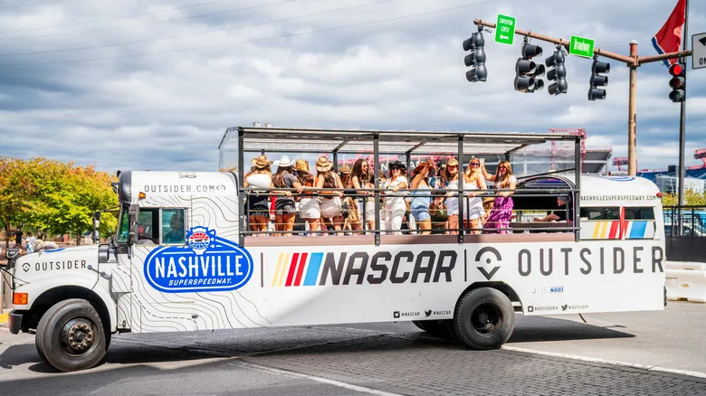 NASCAR-themed open platform bus full of women celebrating and having fun in downtown Nashville