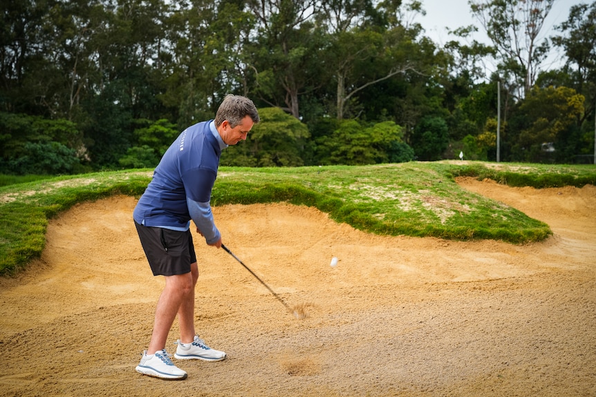 Chris Perry chipping out of a bunker at Parklands Golf Club