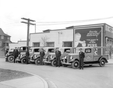 1936: Hilton Dairy fleet of trucks and drivers beside 6395 Fraser St.