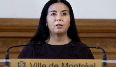 Woman speaks into mics at podium.