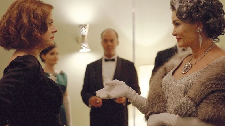 Joan Crawford (Jessica Lange) offers Bette Davis (Susan Sarandon) her hand at a black-tie event in Feud