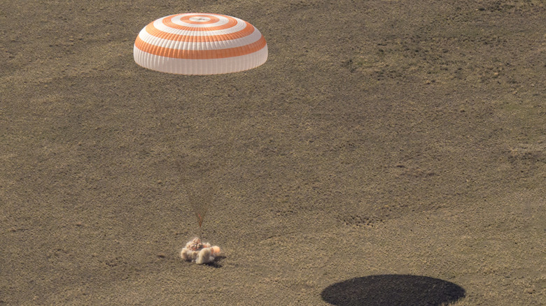 The retrorockets of a Soyuz capsule fire just before landing in Kazakhstan