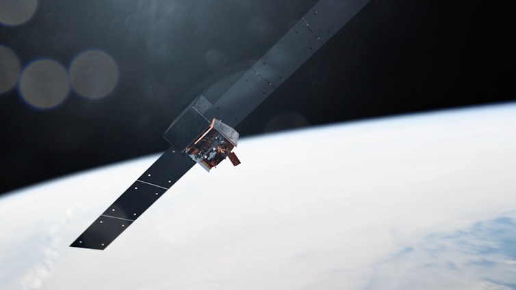 An illustration of the Fermi telescope in orbit over Earth. It looks like a metal box with two solar panels protruding off either side.