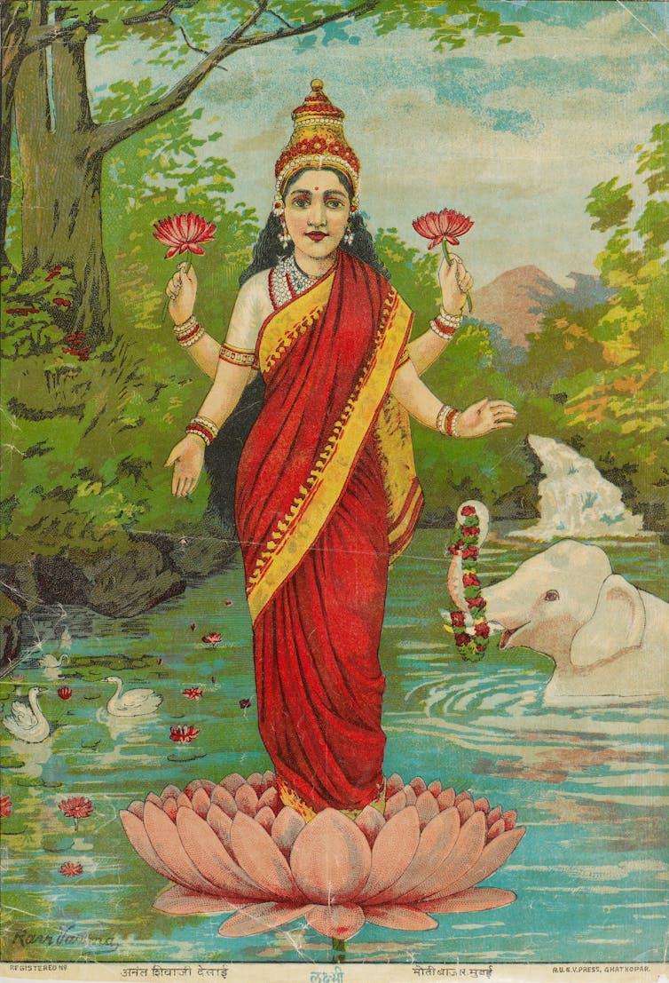 A woman with four arms stands on a lotus flower.