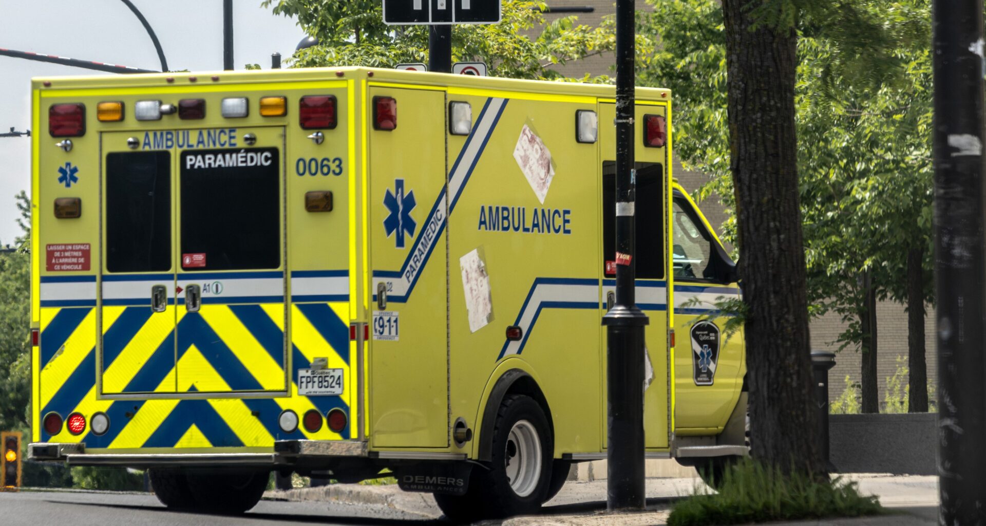 An ambulance turns a corner on a city street.