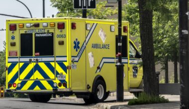 An ambulance turns a corner on a city street.