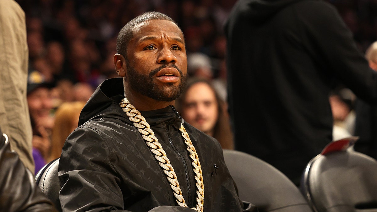 Boxer Floyd Mayweather Jr. sitting courtside at a Los Angeles Lakers basketball game.