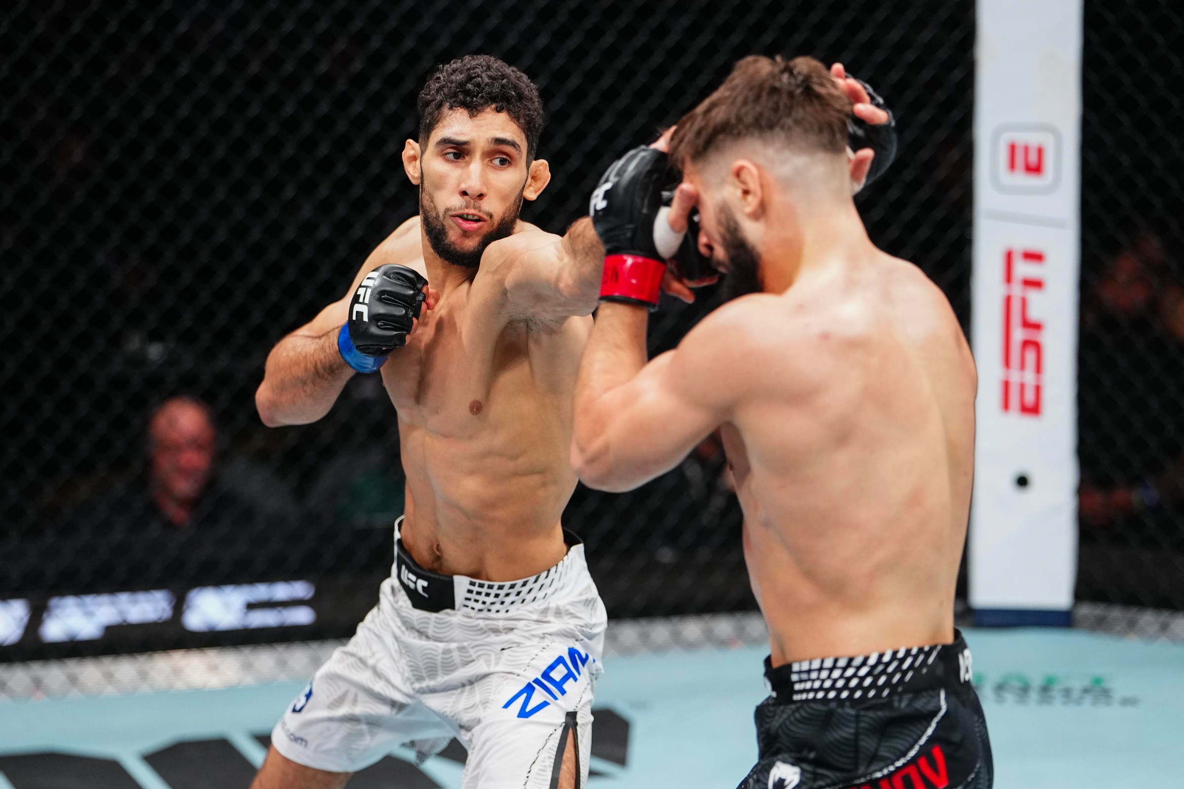 LAS VEGAS, NEVADA - DECEMBER 06: (L-R) Fares Ziam of France punches Nazim Sadykhov of Russia in a lightweight fight during the UFC 323 event at T-Mobile Arena on December 06, 2025 in Las Vegas, Nevada. (Photo by Jeff Bottari/Zuffa LLC)